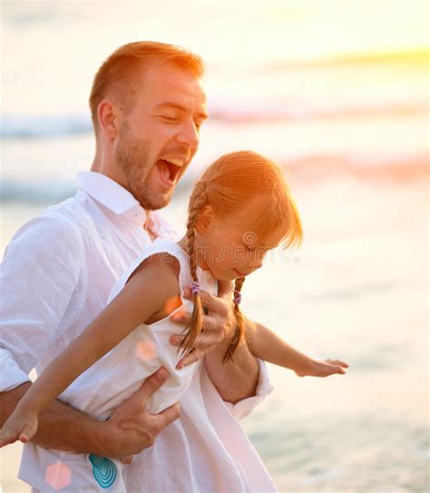 El Padre Joven Y Su Pequeña Hija Adorable Se Divierten En La Playa Foto
