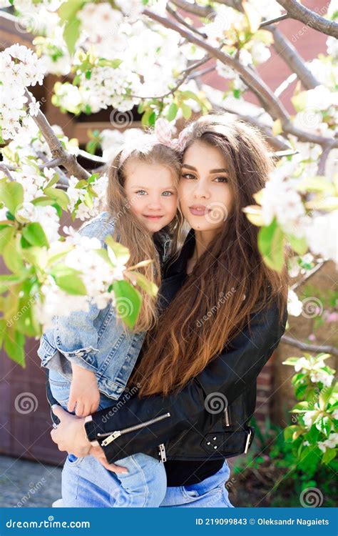 Madre Joven Con Hija Adorable En Parque Con árbol De Flores Imagen De