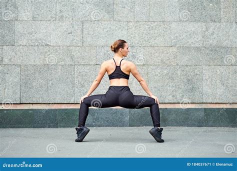 Stretching Woman Fitness Or Gymnast Or Dancer Doing Exercises On Gray
