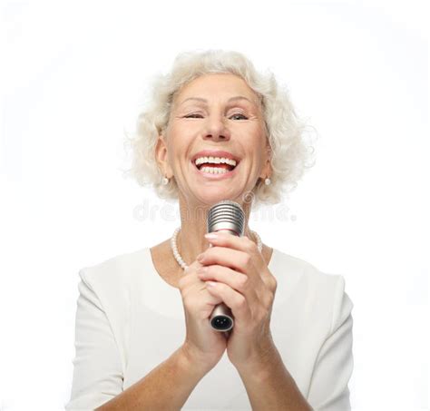 Happy Senior Woman With Curly Hair Singing With Microphone Having Fun Expressing Musical