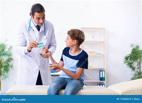 Young Male Doctor Examining Boy In The Clinic Stock Photo Image Of