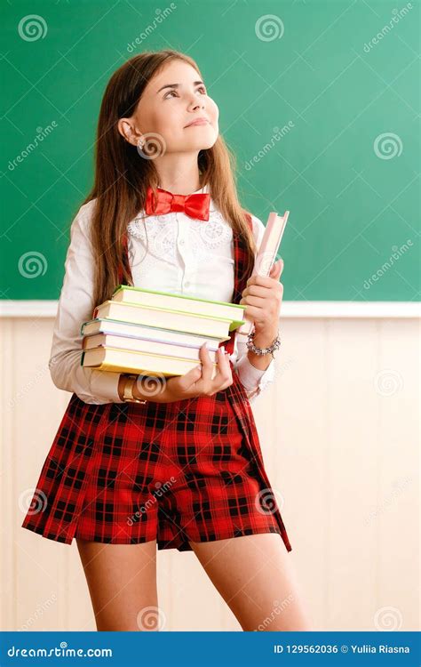 Beautiful Young School Girl In School Uniform Standing With Books In
