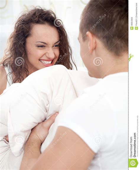 Sexy Young Couple Having Pillow Fight In Bedroom Stock