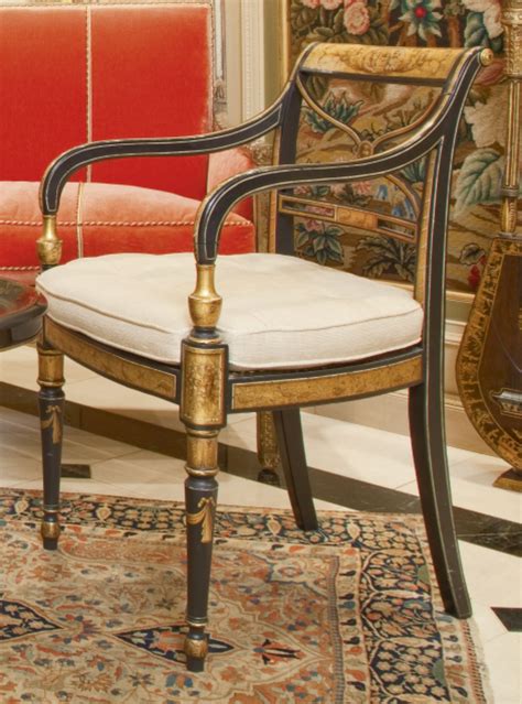 69 A Pair Of Regency Parcel Gilt And Ebonized Caned Armchairs Circa