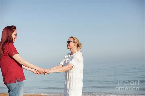 Lesbian Couple Holding Hands On Ocean Beach Photograph By Caia Imagescience Photo Library