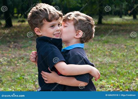 Identical Twin Brothers Embraced Each Other With A Kiss Stock Photo