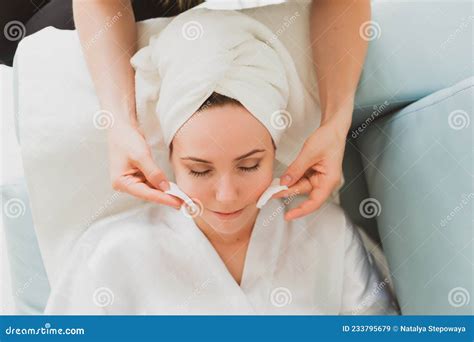 Beautician Makes Facial And Massage To A Young Woman With A Towel On Her Head Stock Image
