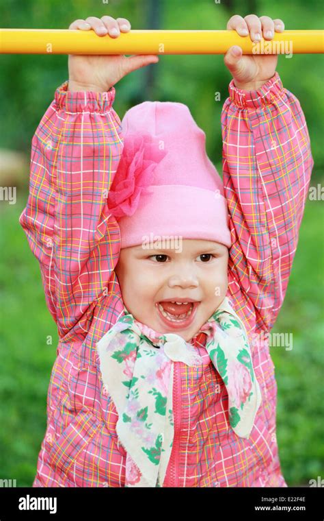 Funny Smiling Caucasian Baby Girl In Pink Outdoor Portrait Stock Photo