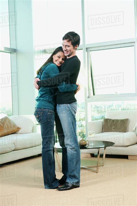 Couple Hugging In Living Room Stock Photo Dissolve