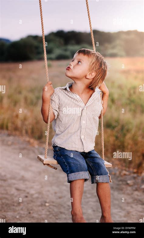 Happy Young Boy Playing On Swing In A Park Stock Photo Alamy