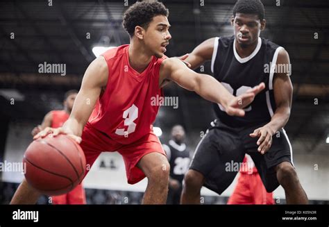 Young Male Basketball Player Dribbling The Ball Protecting From