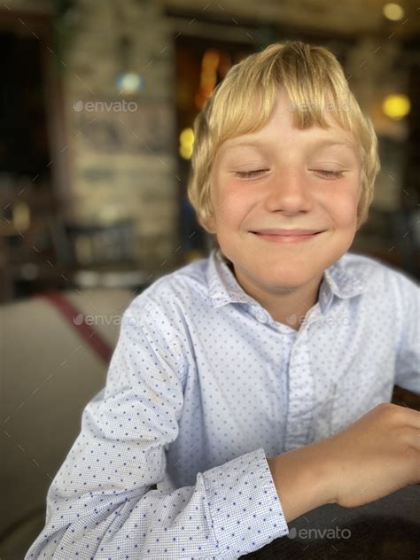 9 Years Old Boy Blonde Caucasian Smiling With Close Eyes Wearing White