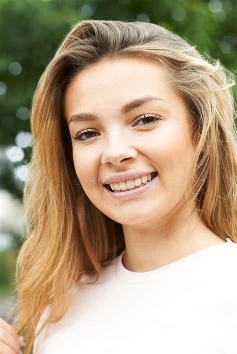 Outdoor Head And Shoulders Portrait Of Smiling Teenage Girl Stock Photo