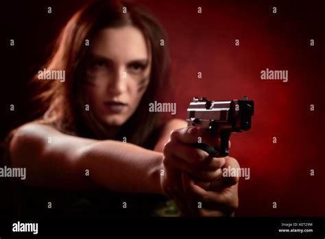 Serious Young Woman With Gun Aiming On Red Background Stock Photo Alamy