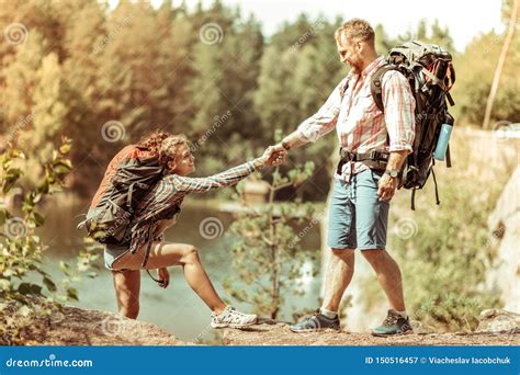 Joyful Nice Man Helping His Girlfriend To Climb Stock Image Image Of
