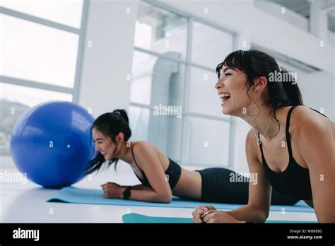 Fit Girls Smiling While Exercising Together In Gym Healthy Young Women