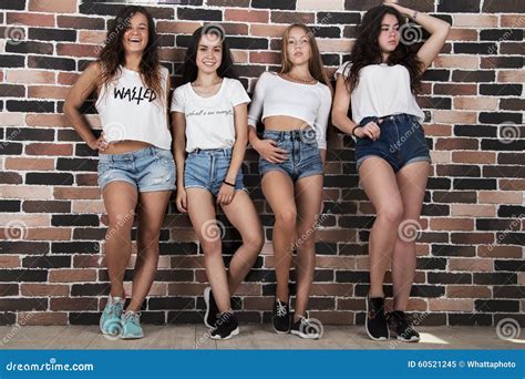 Quatre Jeunes Filles Dans Les Shorts Blancs De T Shirts Et De Jeans