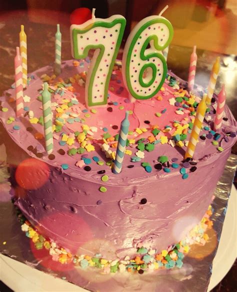 A Birthday Cake With Candles And Confetti On It