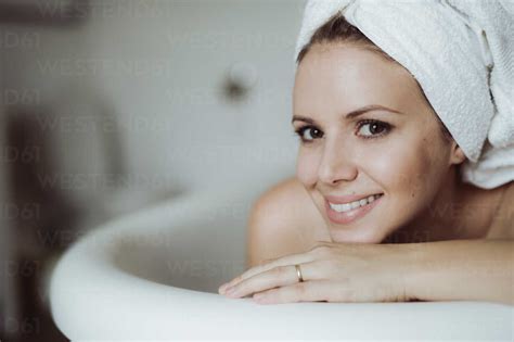 Portrait Of Smiling Woman With Towel Around Her Head Taking A Bath At