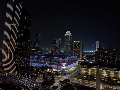 The City Skyline Is Lit Up At Night With Skyscrapers In The Foreground