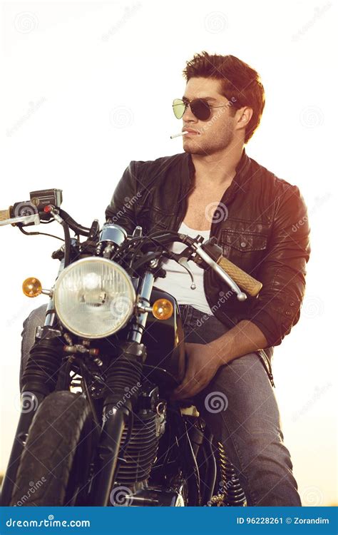 Biker Sitting On Vintage Custom Motorcycle Outdoor Lifestyle Portrait