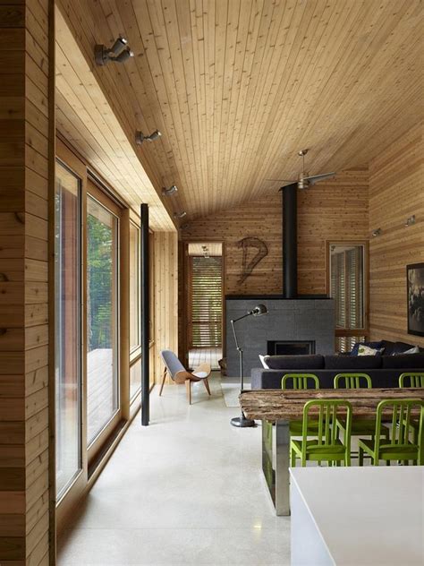 The Interior Of A House With Wood Paneling And Green Chairs