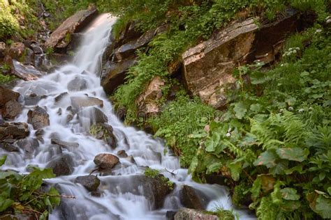 Waterfall And Clear River In A Mountain Stream In A Green Rocky Forest