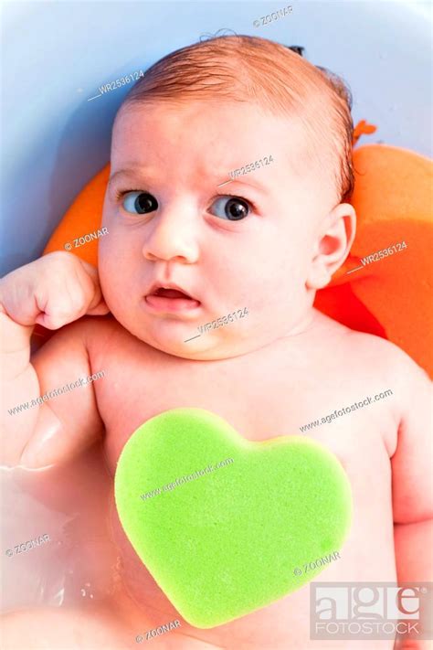 Bathing A Cute Young 3 Months Baby With A Heart Shaped Sponge Stock