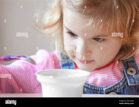 Cute Little Girl Eating Yogurt At Home Closeup Stock Photo Alamy