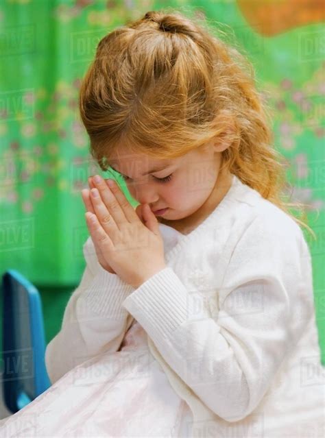 A Young Girl Bowing Her Head In Prayer Stock Photo Dissolve