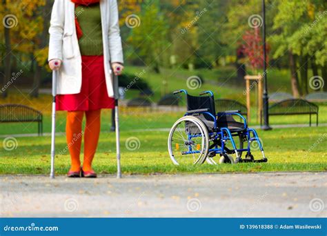 Wheelchair And Woman Practicing Walking On Crutches Stock Photo Image