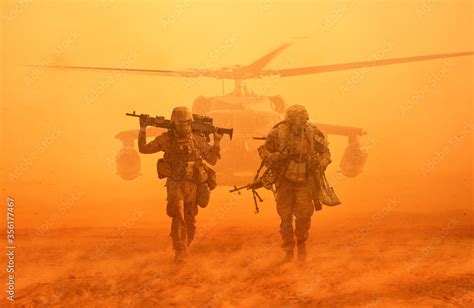 Military Soldiers Walking At Desert With Gun On Their Shoulders In