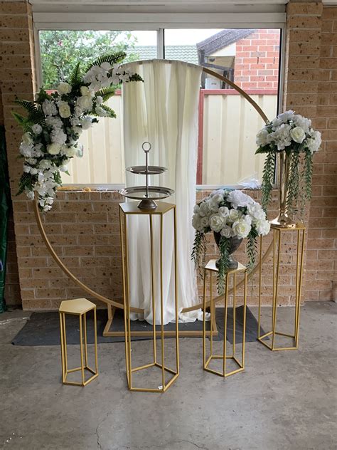 Gold Circle Arch With White Flowers And Gold Pentagon Plinth Wedding