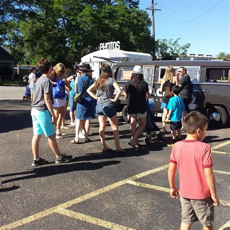 A Group Of People Standing In Front Of An Ice Cream Truck On A Parking Lot