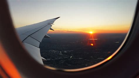 A View From An Airplane Window On The Sun Setting On The Horizon