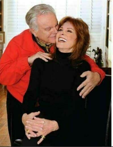 An Older Man And Woman Embracing Each Other