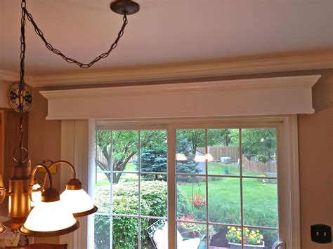 An Open Window In A Living Room Next To A Table With Chairs And Lamps On It