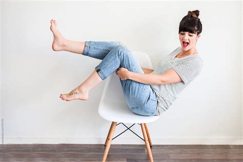 Woman Sitting On A Chair With Feet In The Air By Stocksy Contributor Pink House Organics