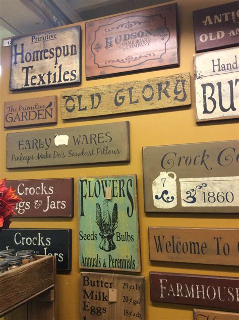 Many Signs Are Hanging On The Wall In A Store With Flowers And Pumpkins