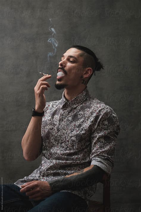 Cool Looking Man Blowing Smoke By Stocksy Contributor Brkati