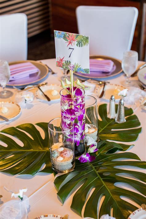 one of our tropical centerpieces with monstera leaves the other tables alternated between mons
