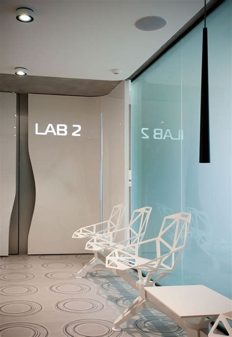 Two White Chairs Sitting Next To Each Other In Front Of A Glass Wall