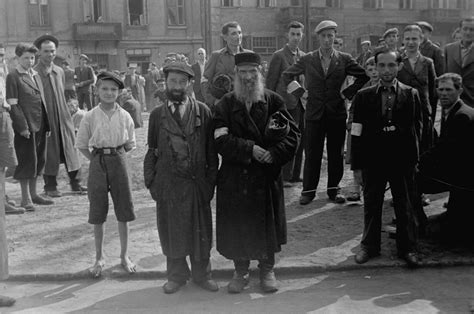 Jewish Men And Youth Are Gathered In An Open Area In The Warsaw Ghetto