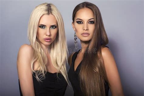 Blond En Donkerbruin Twee Sexy Meisjes Met Het Luxueuze Haar Stellen In