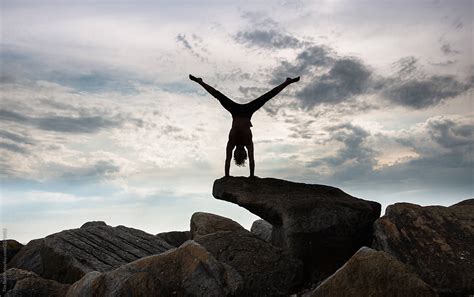 A Young Man Performing A Balancing Act On The Seashore By Stocksy