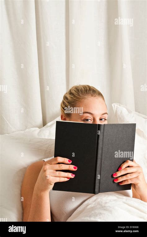 Woman Reading Book In Bed Stock Photo Alamy