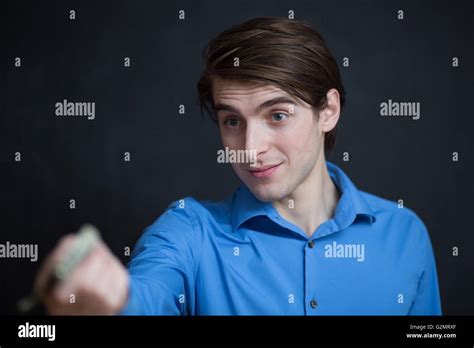 Businessman Giving Money On Dark Background Stock Photo Alamy