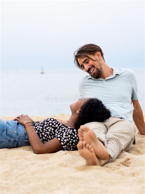 Heterosexual Diverse Young Couple Sitting Affectionately In Front Of The Sea Stock Image Image