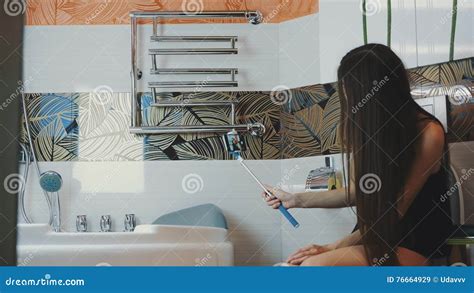 Brunette Girl In Black Shirt Sit On Toilet And Take Selfie On Blue Monopod Stock Video Video