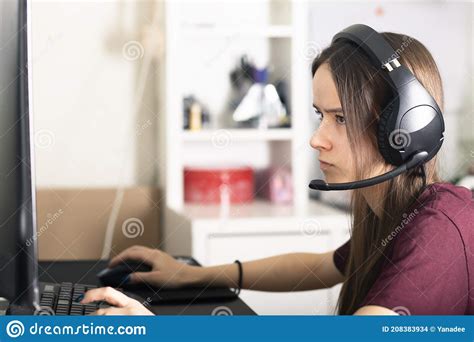 A Girl Gamer Plays An Online Shooter Game On A Computer With Headphones
